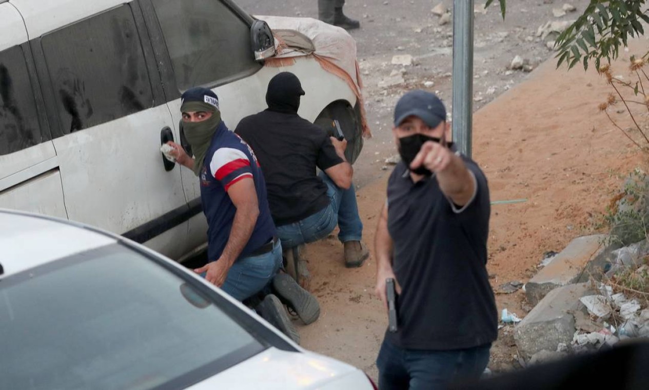 Membros da força de segurança israelense disfarçados são flagrados armados durante protesto de palestinos após israelenses demolirem loja no bairro palestino de Silwan, em Jerusalém Oriental Foto: AMMAR AWAD / REUTERS