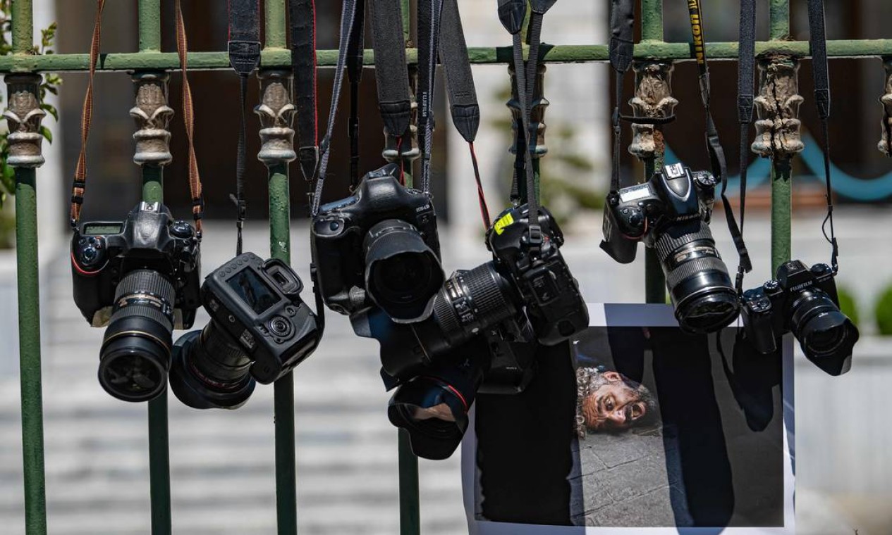 Câmeras e uma foto do fotógrafo da AFP Bulent Kilic são penduradas em frente à Mansão do Governador em Istambul, em sinal de protesto. O fotógrafo foi preso por policiais enquanto cobrindo uma marcha do Orgulho na cidade Foto: YASIN AKGUL / AFP