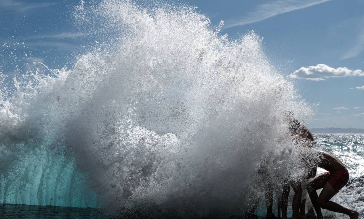 Banhistas brincam nas ondas do mar Mediterrâneo, em Nice, na França Foto: VALERY HACHE / AFP