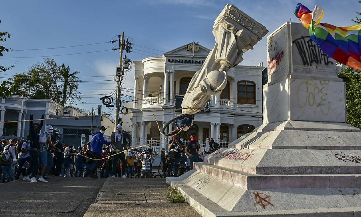 Manifestantes derrubam uma estátua de Cristóvão Colombo durante uma manifestação contra o governo em Barranquilla, Colômbia Foto: MERY GRANDOS HERRERA / AFP