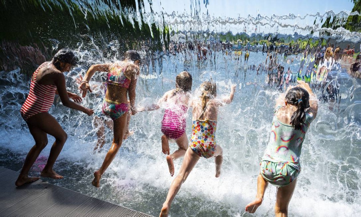 Meninas mergulham na cachoeira de um parque em Washington, durante onda de calor que atinge grande parte dos Estados Unidos Foto: JIM WATSON / AFP
