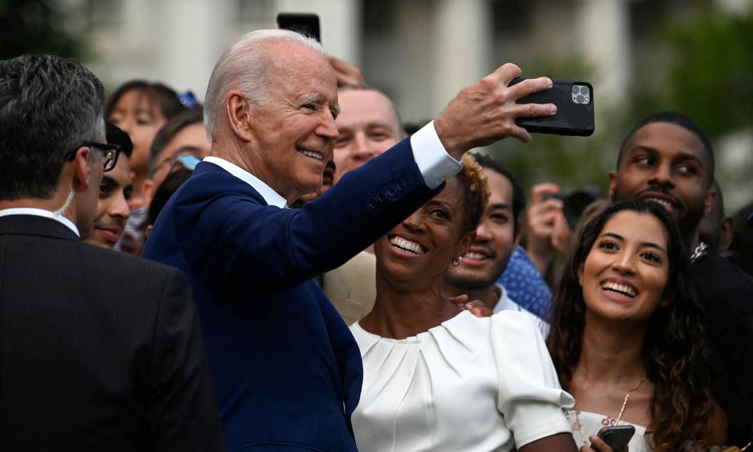 O presidente dos EUA Joe Biden posa para uma selfie com convidados após fazer um discurso durante as celebrações do Dia da Independência no gramado sul da Casa Branca em Washington Foto: ANDREW CABALLERO-REYNOLDS / AFP