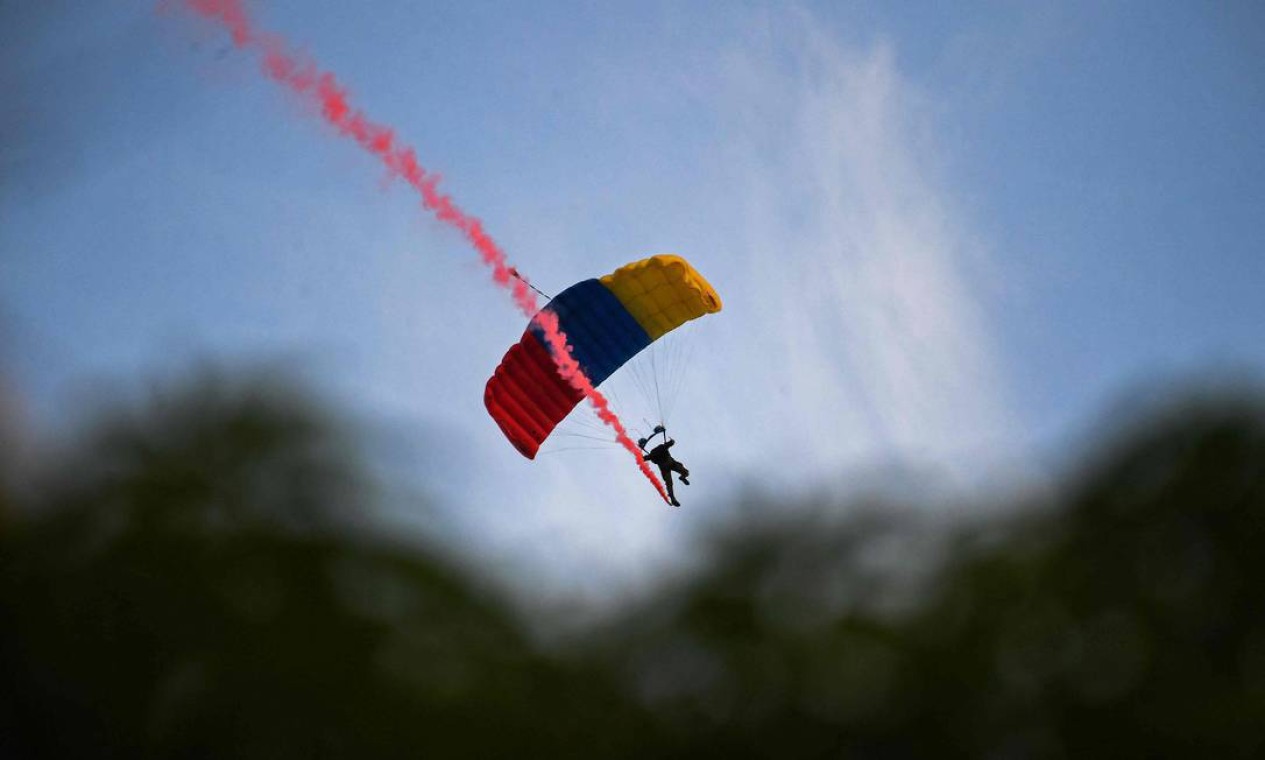 Paraquedista do Exército da Venezuela salta de um avião durante um desfile militar para comemorar o 210º aniversário da Independência da Venezuela em Caracas Foto: FEDERICO PARRA / AFP