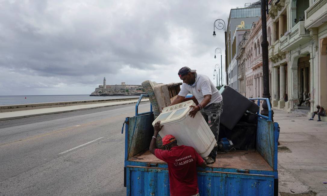 Homens carregam caminhão com elotrodomésticos para escaparem da tempestade Elsa, em Havana Foto: ALEXANDRE MENEGHINI / REUTERS