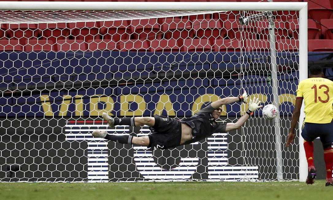 Martínez voa para pegar a cobrança do colombiano Mina; goleiro argentino foi decisivo, com três defesas Foto: Pablo Jacob / Agência O Globo