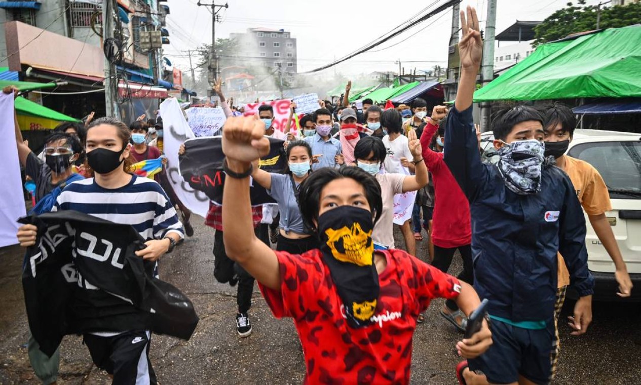 Manifestantes marcham, em Yangon, contra o golpe militar e para marcar o aniversário de protestos estudantis de 1962 contra a primeira junta de Mianmar Foto: STR / AFP