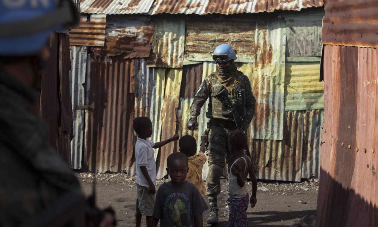 Militar do exército interage com criança na favela de Cite Solei Foto: Daniel Marenco / Agência O Globo - 30/08/2017