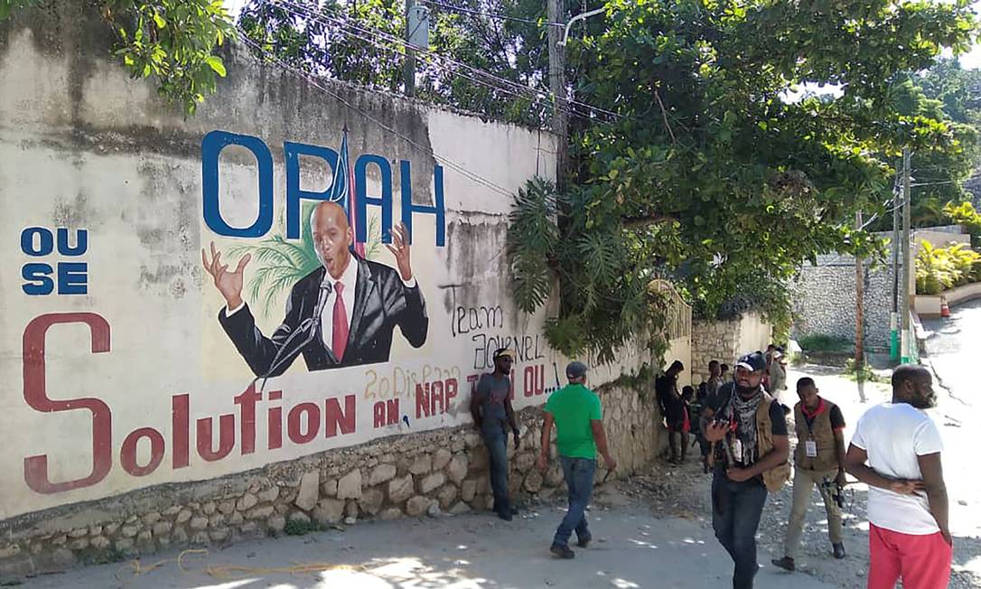 Pessoas caminham diante de mural com imagem do presidente Jovenel Moïse, assassinado nesta quarta-feira em Porto Príncipe Foto: STRINGER / REUTERS