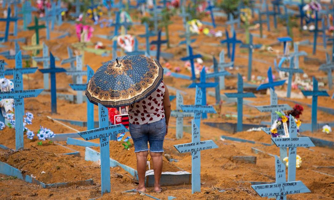 Mulher visita cemitério em Manaus Foto: MICHAEL DANTAS / AFP