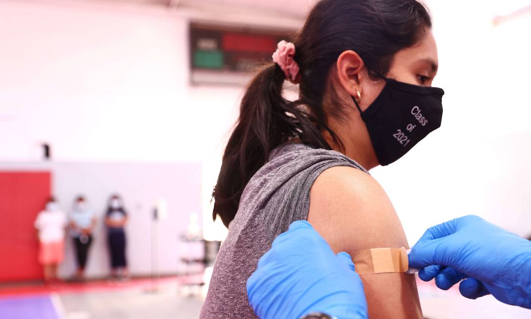 Estudante usando uma máscara facial da classe 2021 após receber uma dose de vacina contra a Covid-19 em Winnetka, Califórnia, nos EUA Foto: MARIO TAMA / AFP