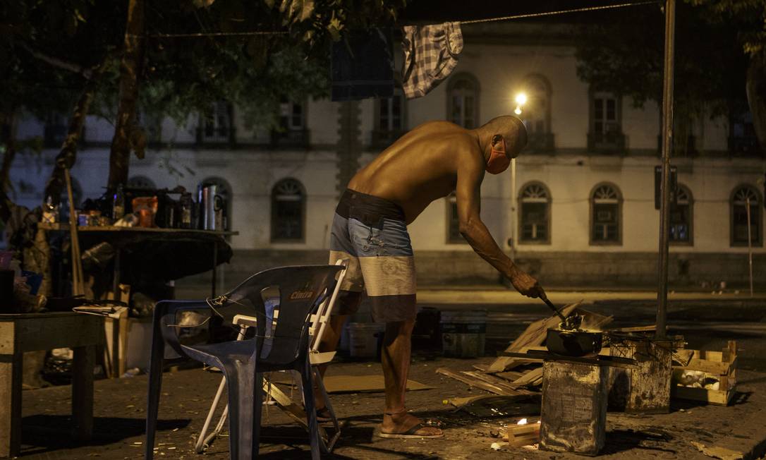Homem prepara comida em rua do centro do Rio Foto: Alexandre Cassiano / Agência O Globo (17/08/2020)