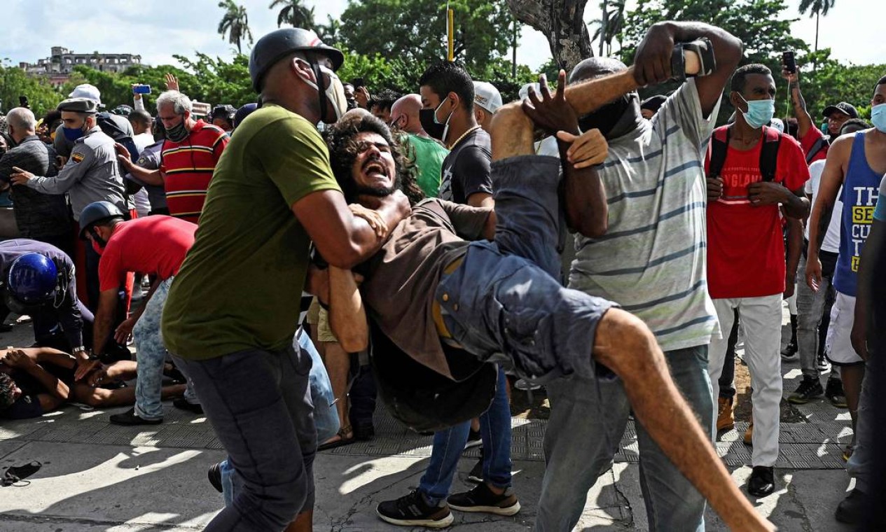 Homem é preso durante uma manifestação contra o governo do presidente cubano. As manifestações começaram pela manhã de domingo, na cidade de San Antonio de los Baños, a sudoeste de Havana Foto: YAMIL LAGE / AFP