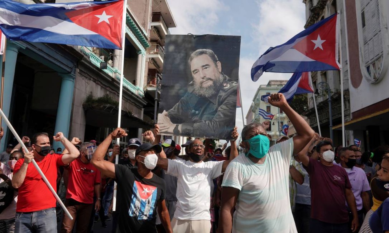 Apoiadores do governo exibem uma fotografia do falecido presidente cubano Fidel Castro durante protestos contra e em apoio ao governo. O presidente Miguel Díaz-Canel convocou 'revolucionários' a irem às ruas em defesa do governo Foto: ALEXANDRE MENEGHINI / REUTERS
