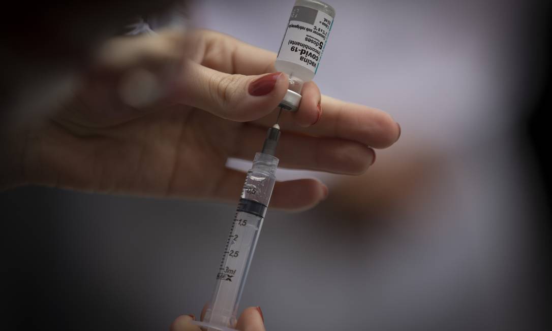Profissional prepara dose de vacina para ser aplicada em público de posto de saúde Foto: Márcia Foletto / Agência O Globo