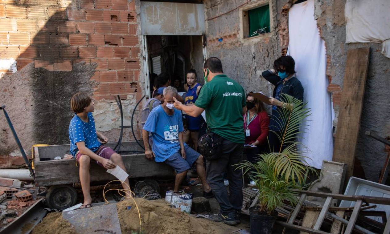 Servidores da prefeitura conversam com famílias que tiveram a casa demolida Foto: Brenno Carvalho / Agência O Globo
