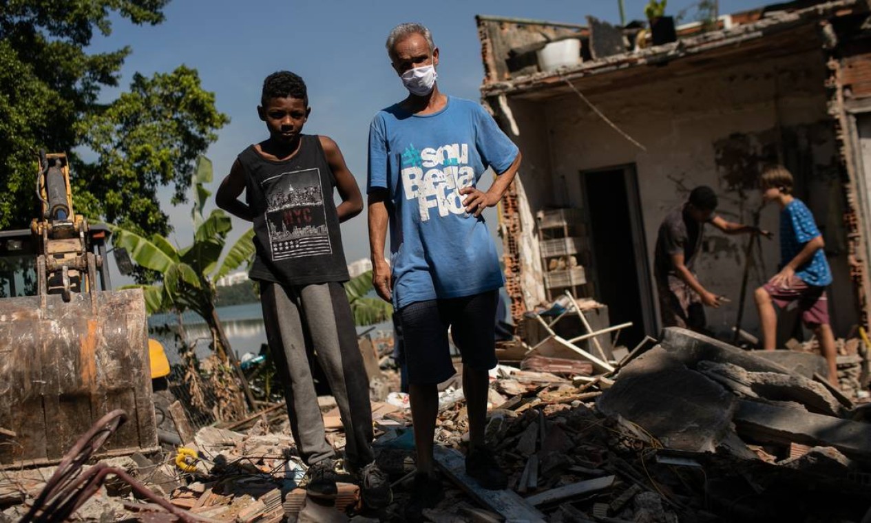 Gilberto Moreira Leite e seu filho de 9 anos estão sobre os escombros do que um dia foi seu lar por 30 anos Foto: Brenno Carvalho / Agência O Globo