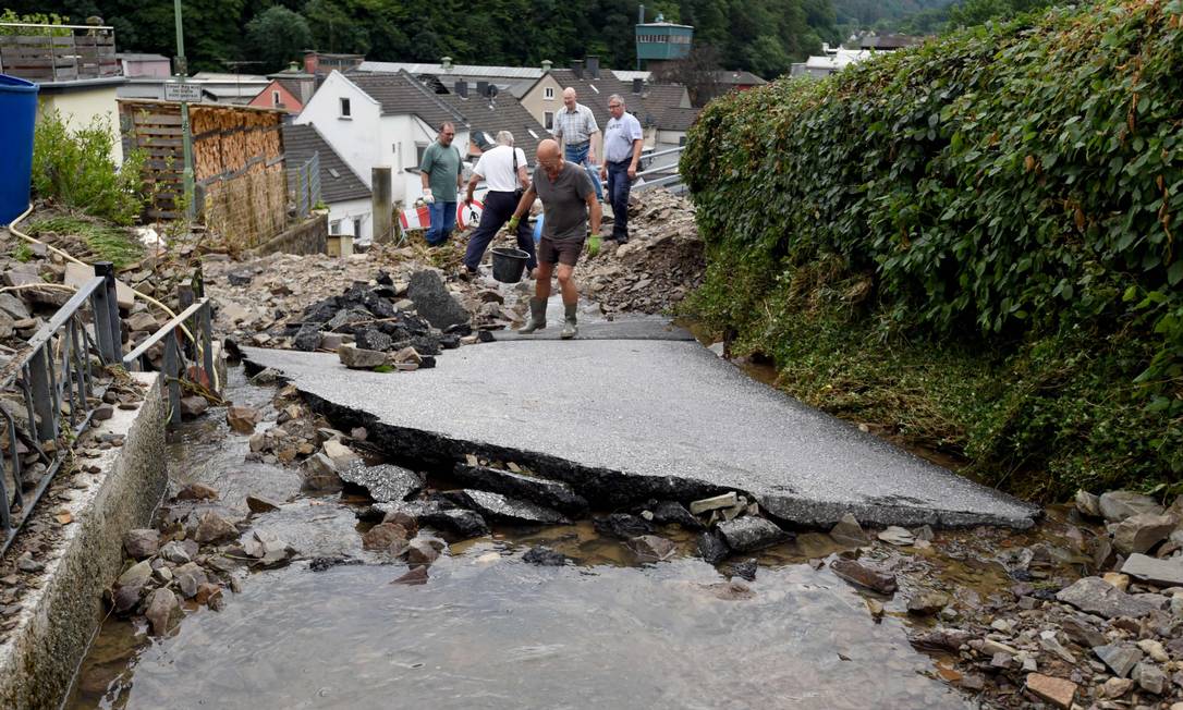 I residenti eliminano le macerie da una strada distrutta durante una tempesta che ha causato ingenti danni ad Hagen, in Germania Foto: INA FASSBENDER / AFP