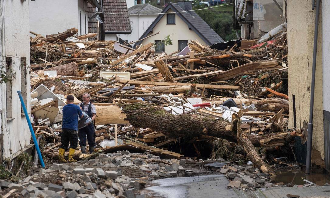 Zwei Männer versuchen, in Schuld bei Bad Neuenahr Eigentum in der Nähe der Trümmer der durch Hochwasser zerstörten Häuser zu schützen Foto: BERND LAUTER / AFP