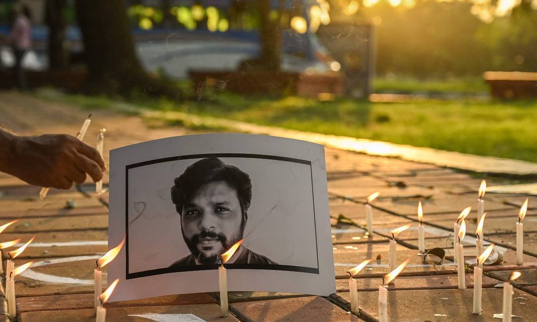Velas são colocadas por jornalistas junto à foto de Danish Siddiqui num tributo em Calcutá na Índia Foto: DIBYANGSHU SARKAR / AFP