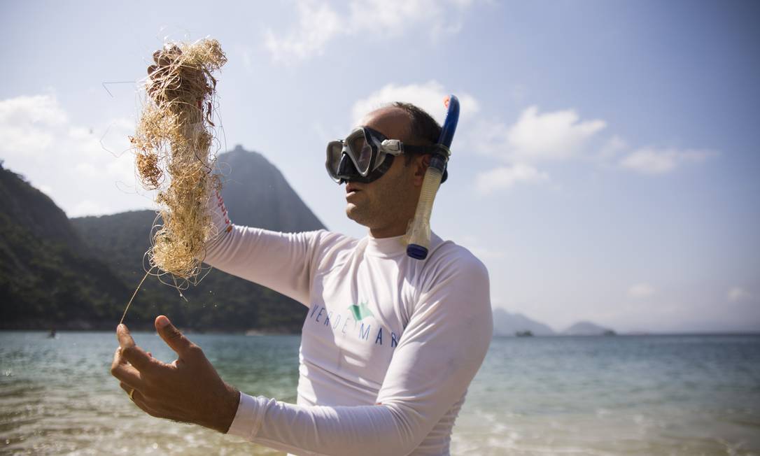 Caio Salles, jornalista e coordenador do Projeto Verde Mar, mostra resíduos da prática de pescaria encontrados no mar Foto: Maria Isabel Oliveira / Agência O Globo
