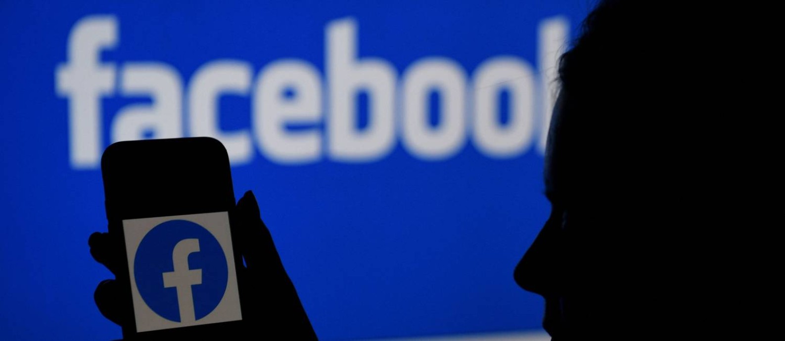 Logo do Facebook é vista na tela de um smartphone Foto: OLIVIER DOULIERY / AFP