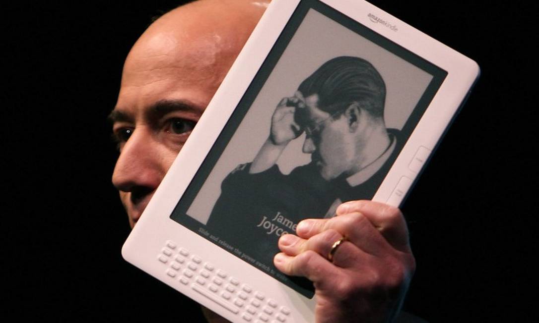 Jeff Bezos e o Kindle, em 2009 Foto: SPENCER PLATT / AFP