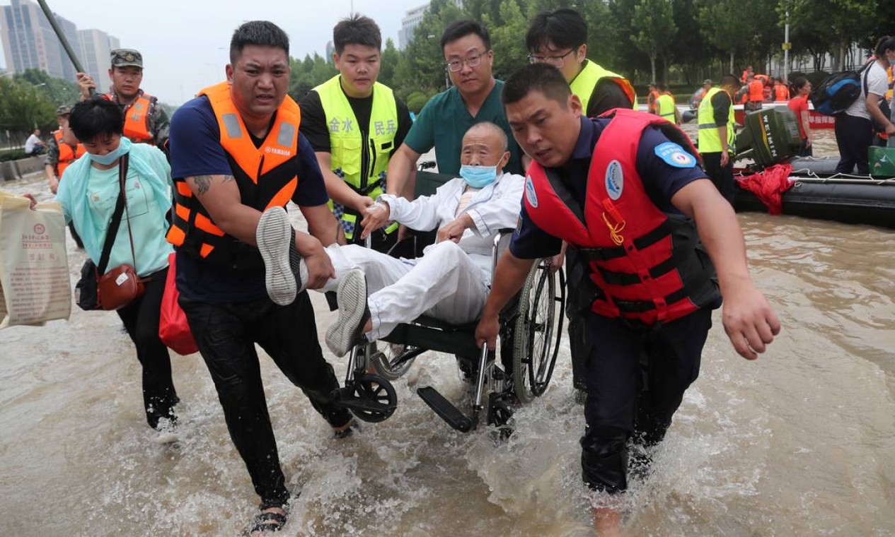 Pacietne cadeirante é carregado por equipe de resgate Foto: CHINA DAILY / REUTERS