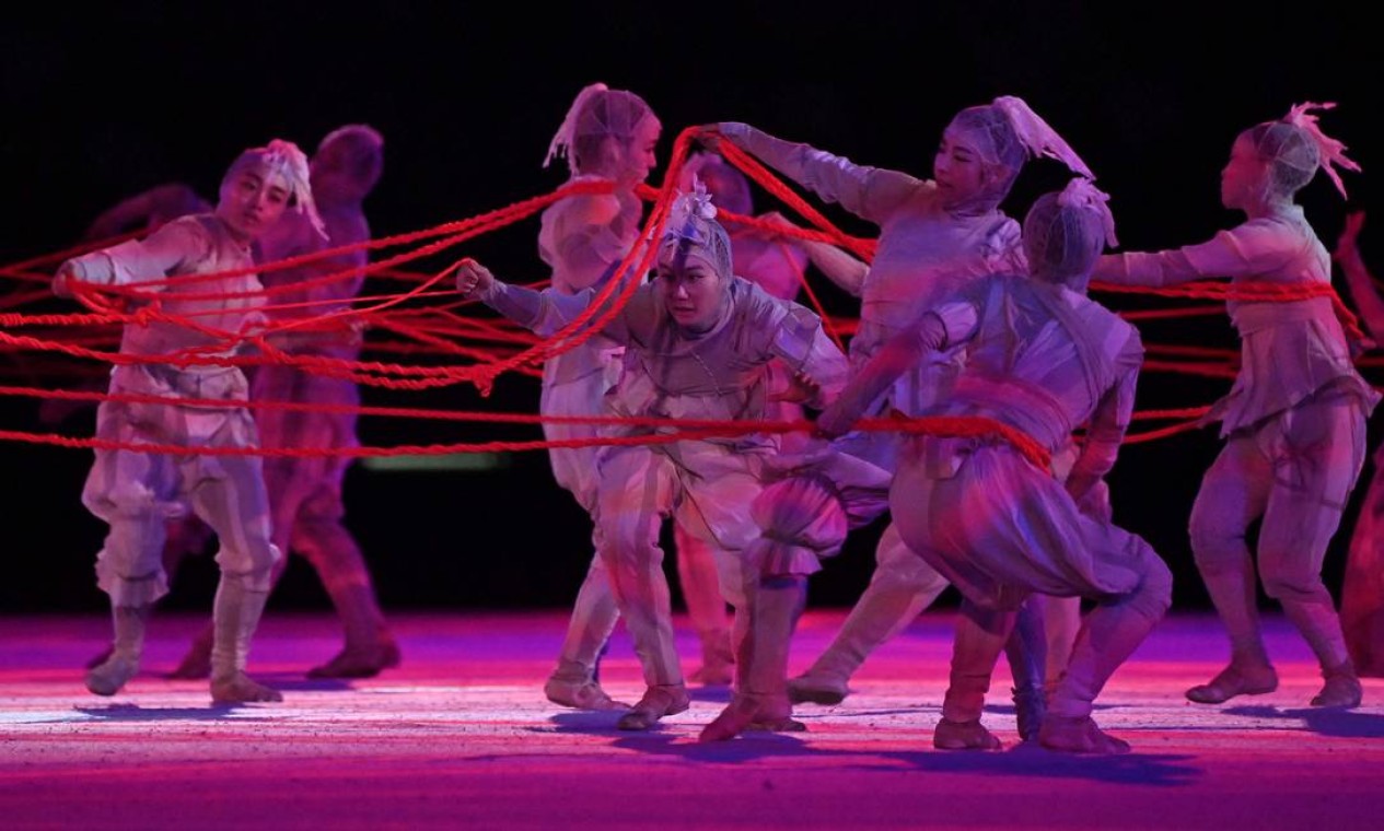 Dançarinos performam com obra da artista japonesa Chiharu Shiota, com fios vermelhos que representam os músculos que dão movimento do corpo humano Foto: ANDREJ ISAKOVIC / AFP
