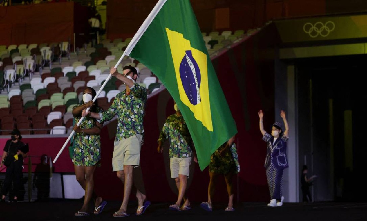 O jogador de vôlei Bruno Rezende, o Bruninho, carregou a bandeira no desfile da delegação brasileira junto com a judoca Ketleyn Quadros Foto: HANNAH MCKAY / AFP