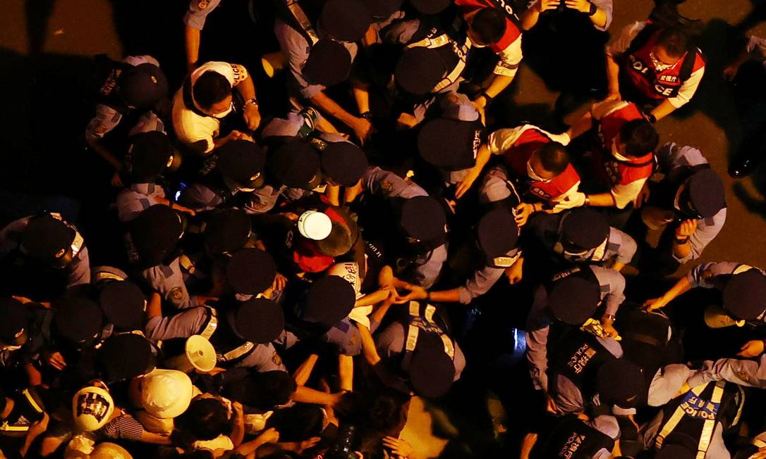 Manifestantes contra a realização dos Jogos enfrentam a polícia do lado de fora do estádio, durante a cerimônia Foto: EDGAR SU / REUTERS