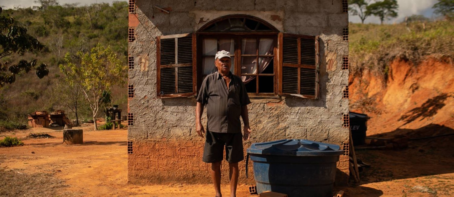 O agricultor César Augusto Passos da Silva em frente a sua casa: nem sempre a caixa d'água está cheia Foto: Brenno Carvalho / Agência O Globo