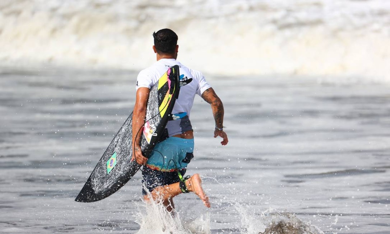 Italo troca de prancha para voltar para o mar Foto: LISI NIESNER / REUTERS