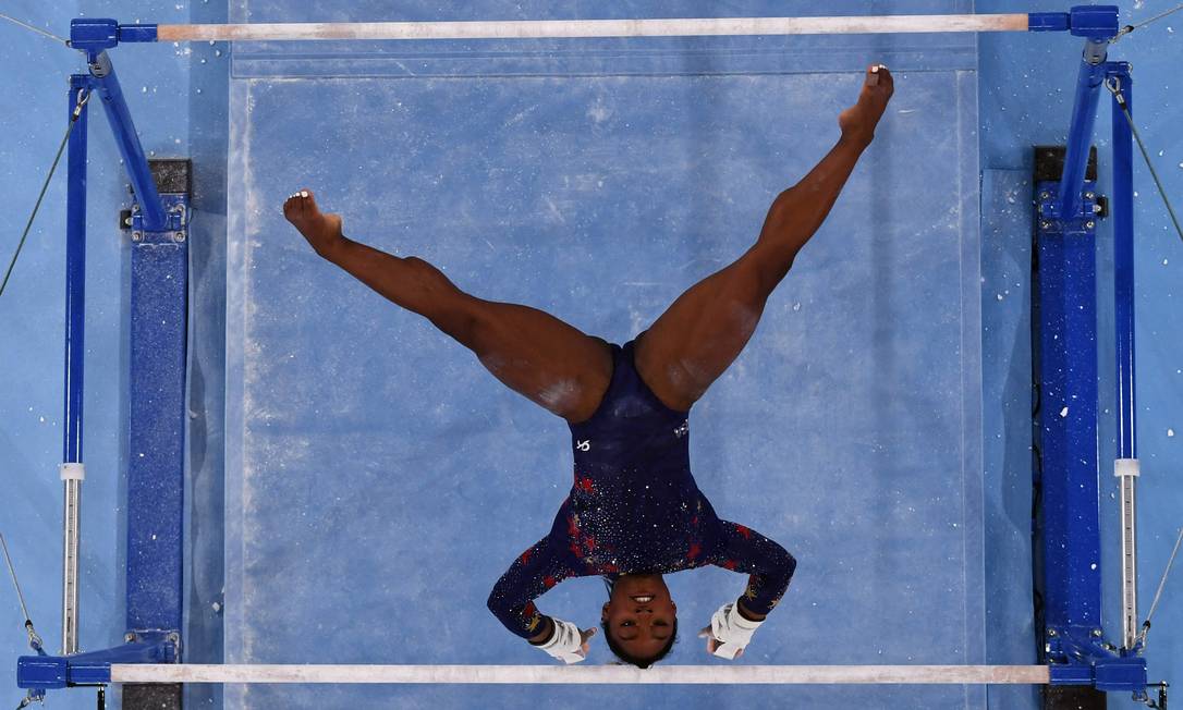 Biles em sua apresentação nas barras assimétricas durante as classificatórias. Foto: LOIC VENANCE / AFP