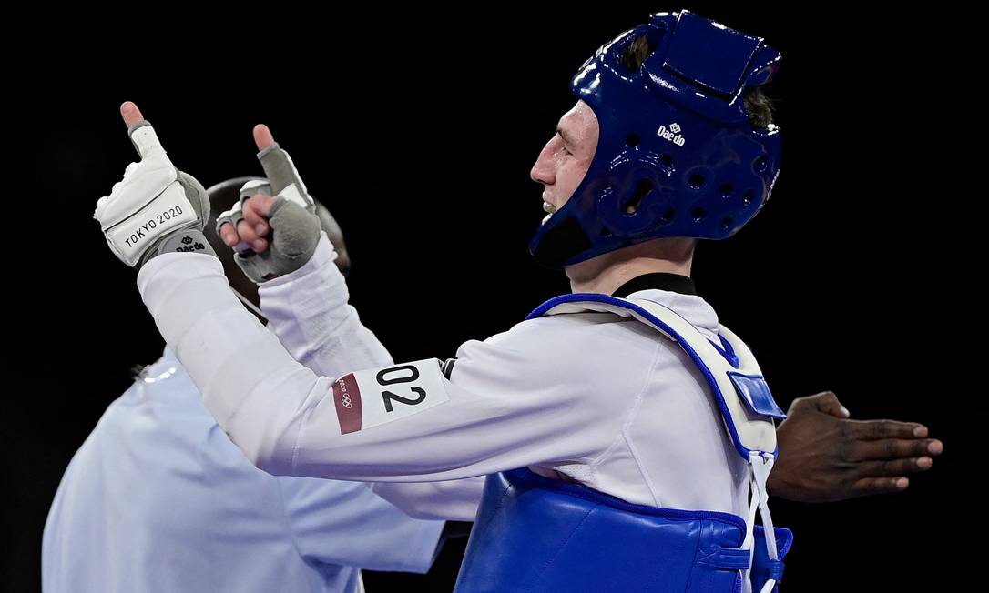 Bradly Sinden (azul), da Grã-Bretanha, comemora a vitória na semifinal masculina de taekwondo de 68 kg contra o chinês Zhao Shuai Foto: JAVIER SORIANO / AFP