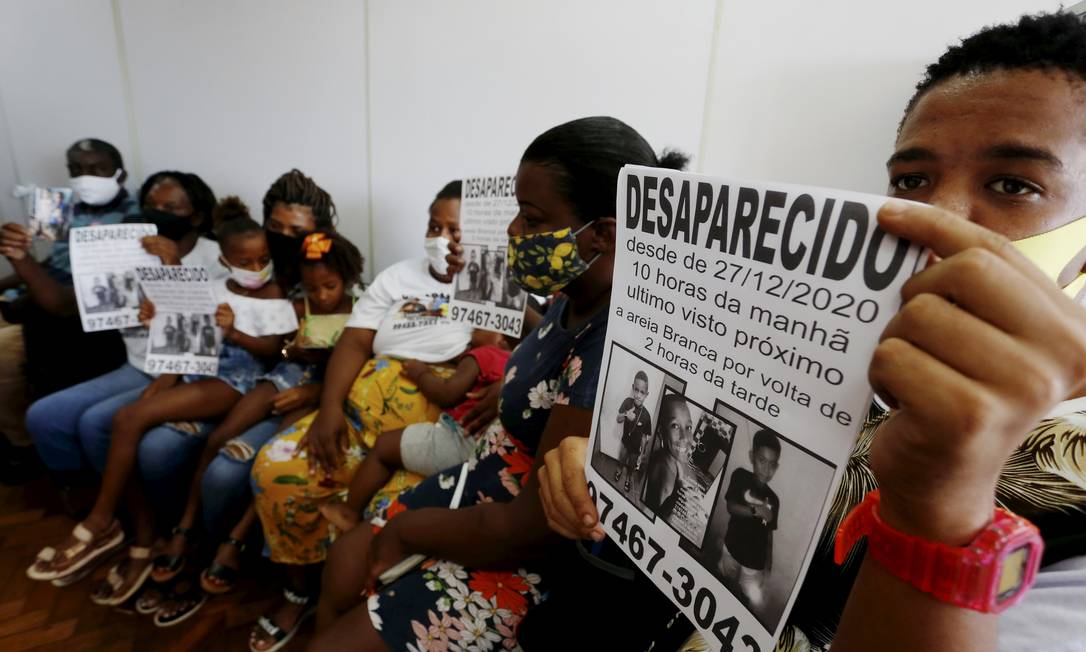 Parentes mostram cartazes com fotos das crianças: famílias criticam a investigação do caso Foto: Fabiano Rocha / Agência O Globo - 02/02/2021