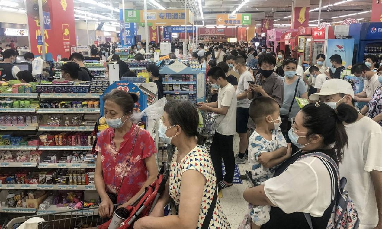 Grandes filas, carrinhos de compras lotados e prateleiras vazias. Cenas comuns no início da pandemia estão de volta à rotina de Wuhan Foto: STR / AFP