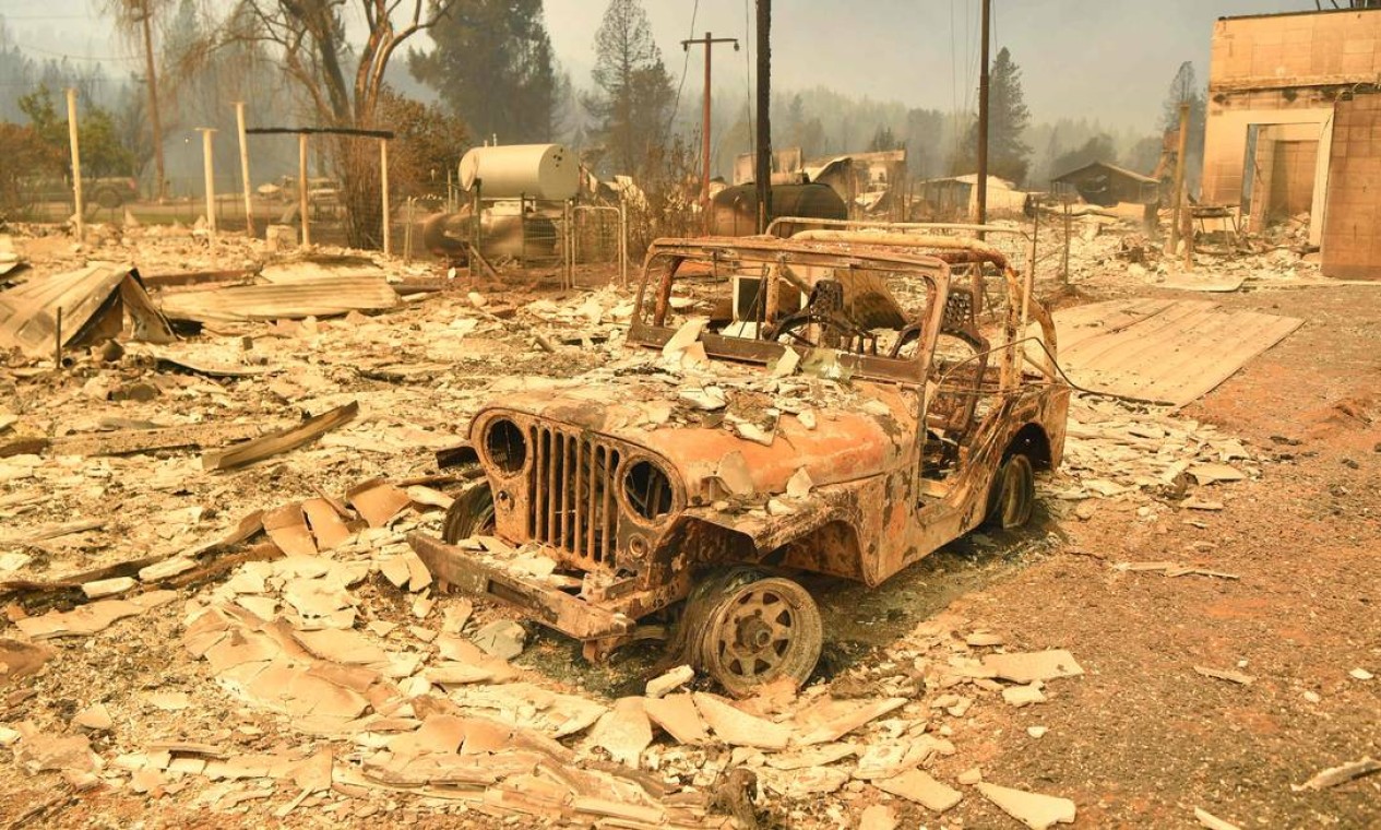 Um jipe queimado entre destroços de uma casa em Greenville, Califórnia, EUA, durante o incêndio Dixie em agosto de 2021 Foto: JOSH EDELSON / AFP