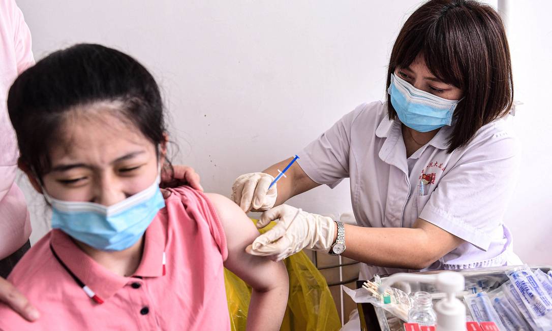 Jovem recebe vacina contra a Covid-19 em Shenyang, na China Foto: STR / AFP