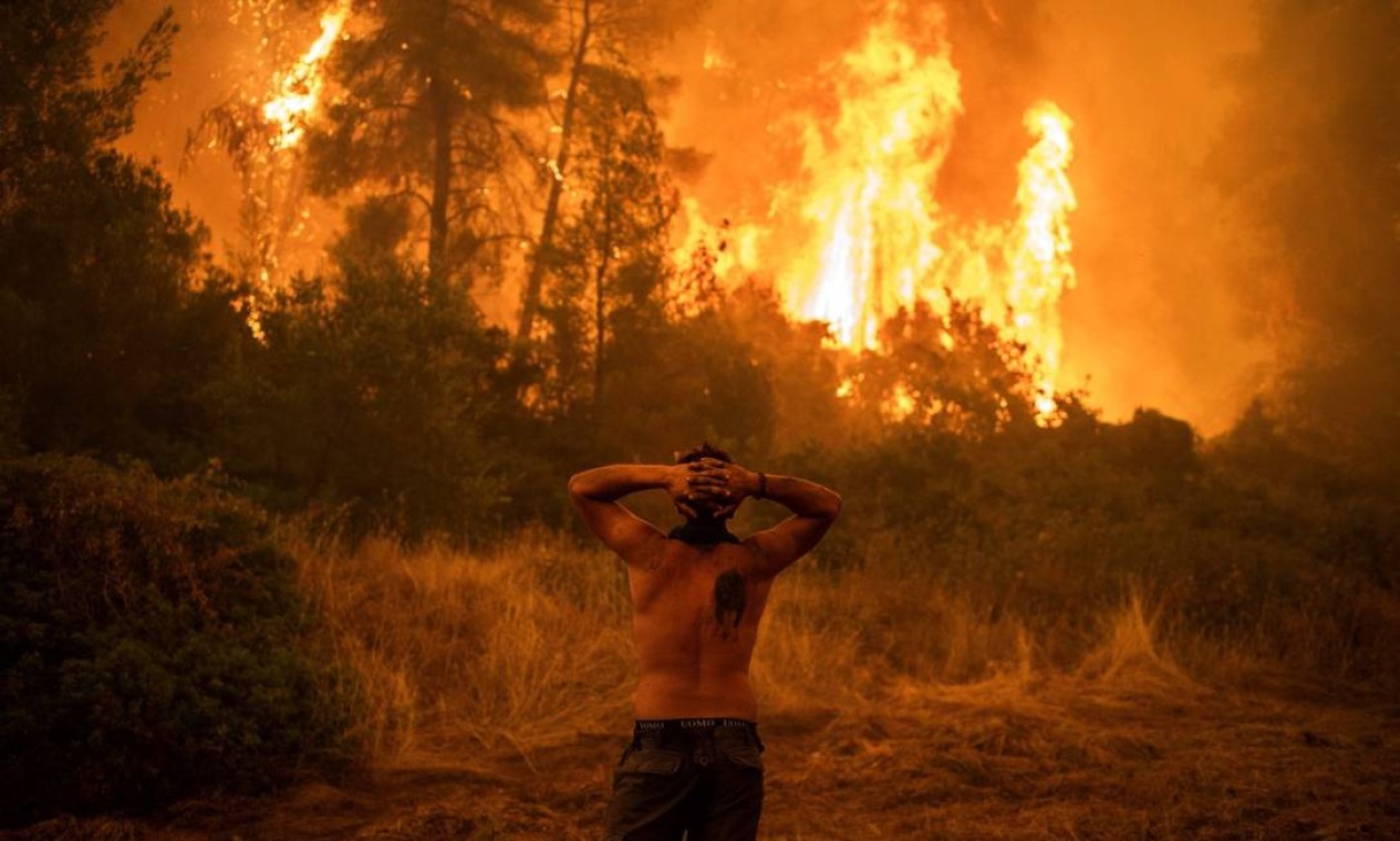 Morador lamenta incêndio na ilha de Eubeia, Grécia Foto: ANGELOS TZORTZINIS / AFP