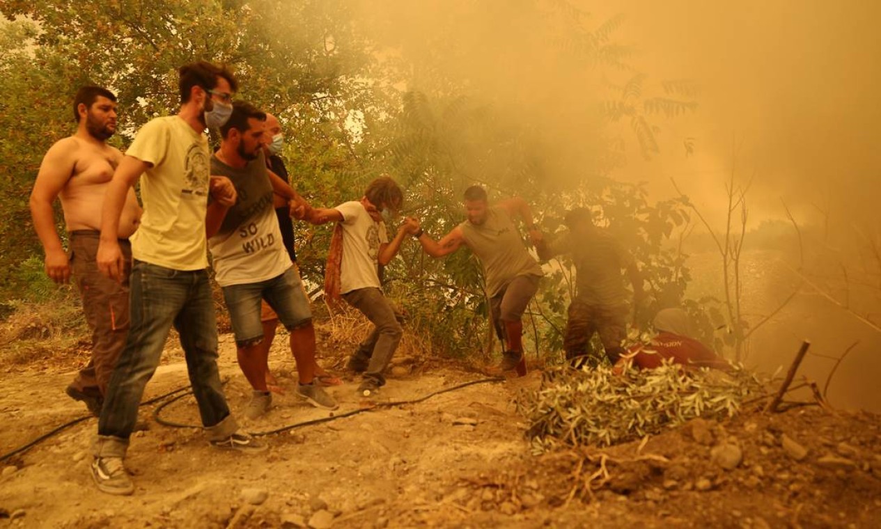 Moradores fazem escada humana durante incêndio na Ilha de Eubeia, na Grécia Foto: STRINGER / REUTERS