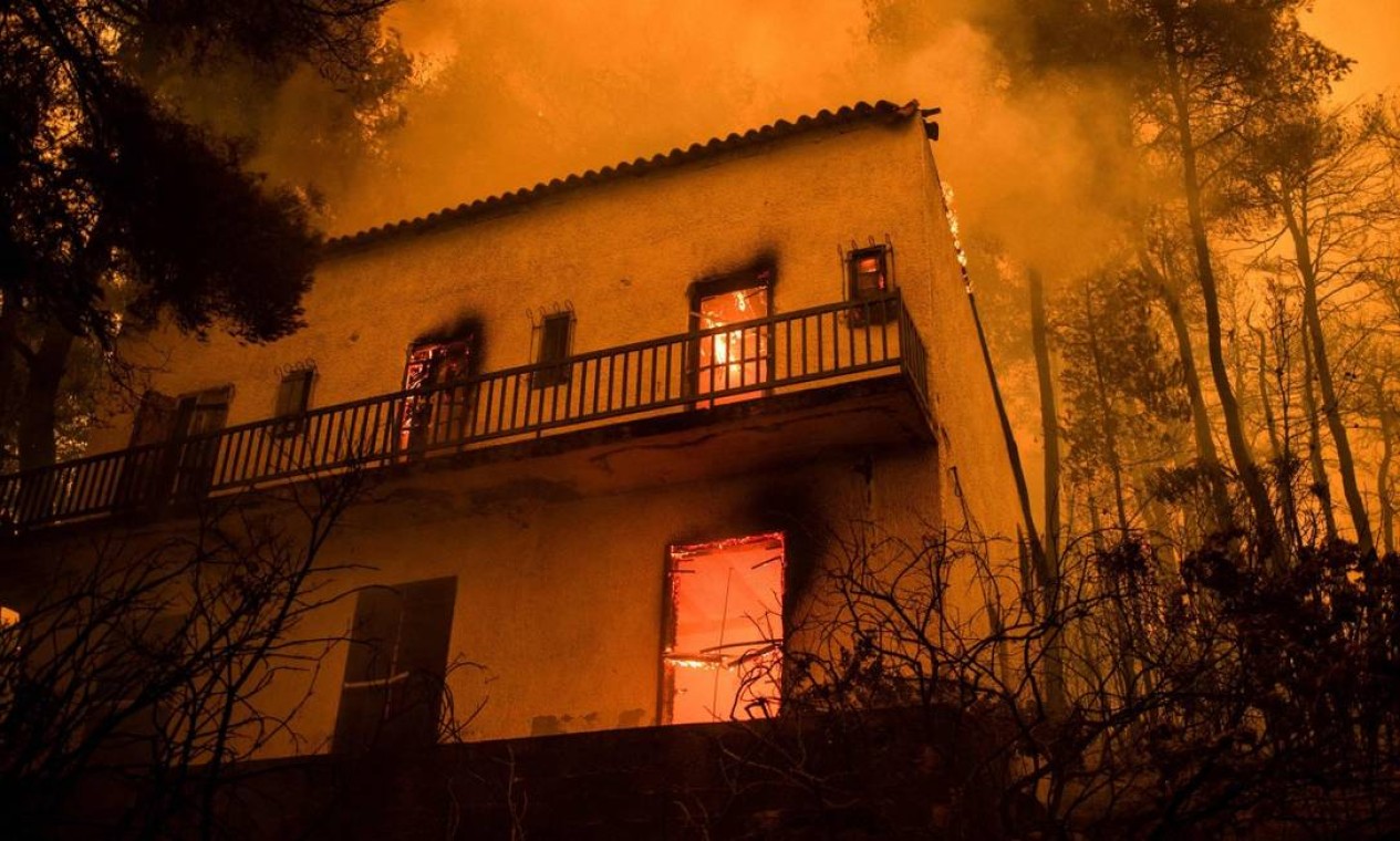 Casa é destruída pelas chamas durante incêndio da Ilha de Ilha de Eubeia, na Grécia Foto: ANGELOS TZORTZINIS / AFP