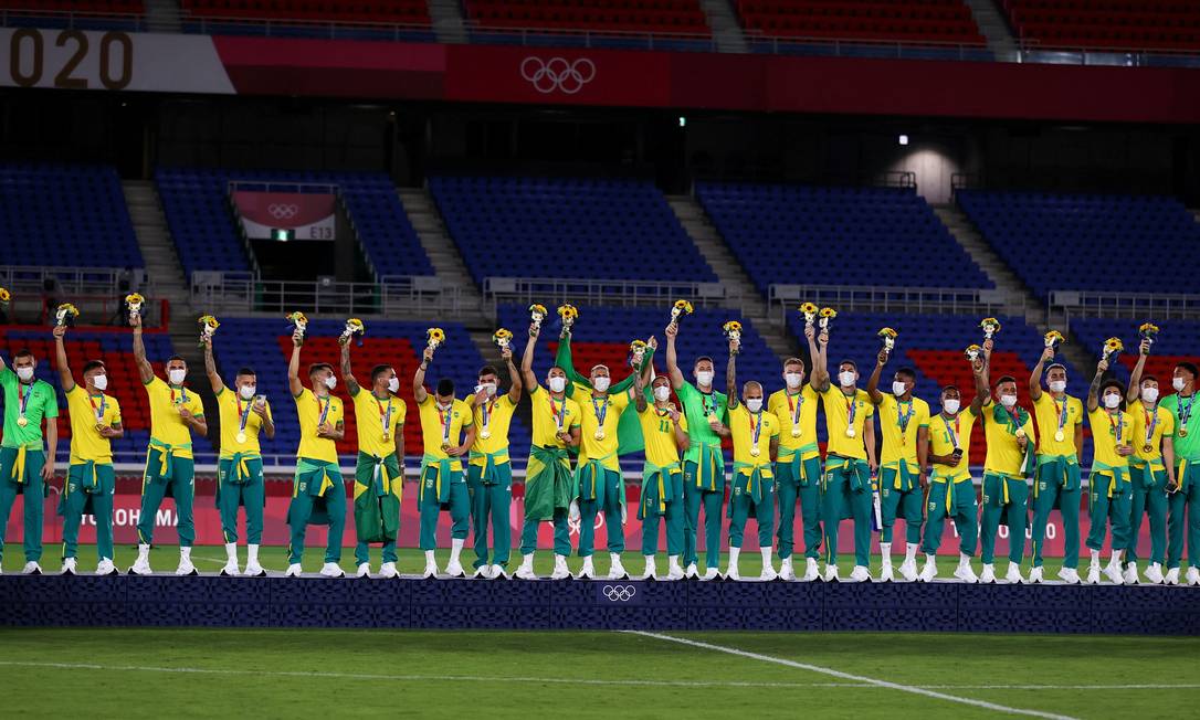 Jogadores do Brasil amarraram casaco do COB na cintura na cerimônia de premiação no futebol masculino Foto: AMR ABDALLAH DALSH / REUTERS