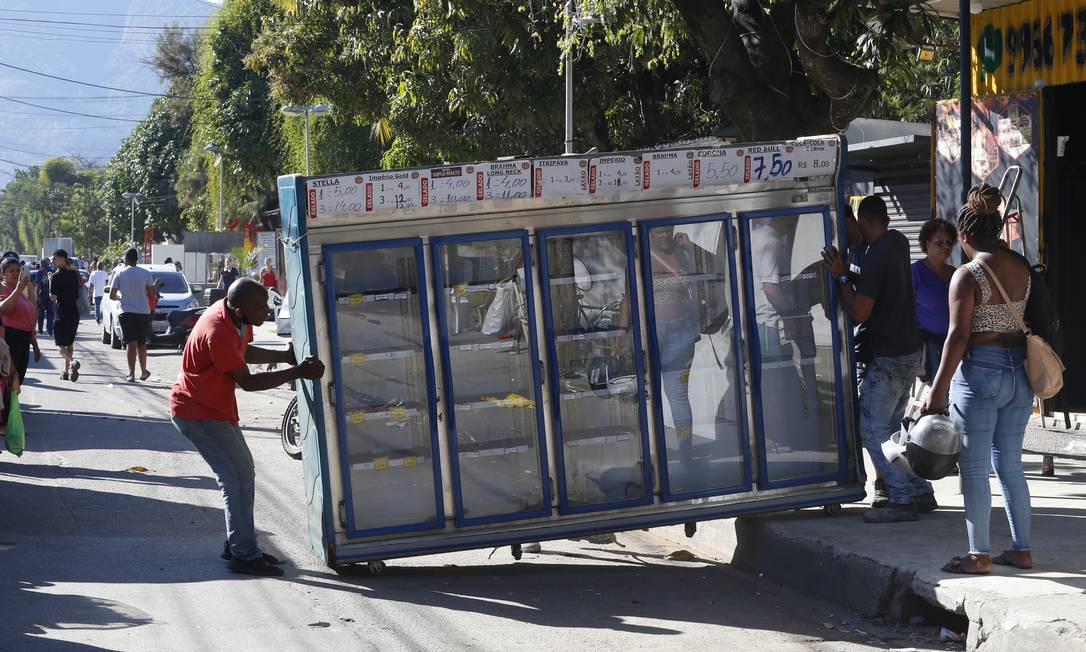 Comerciante retira equipamento às pressas Foto: Fabiano Rocha / Agência O Globo