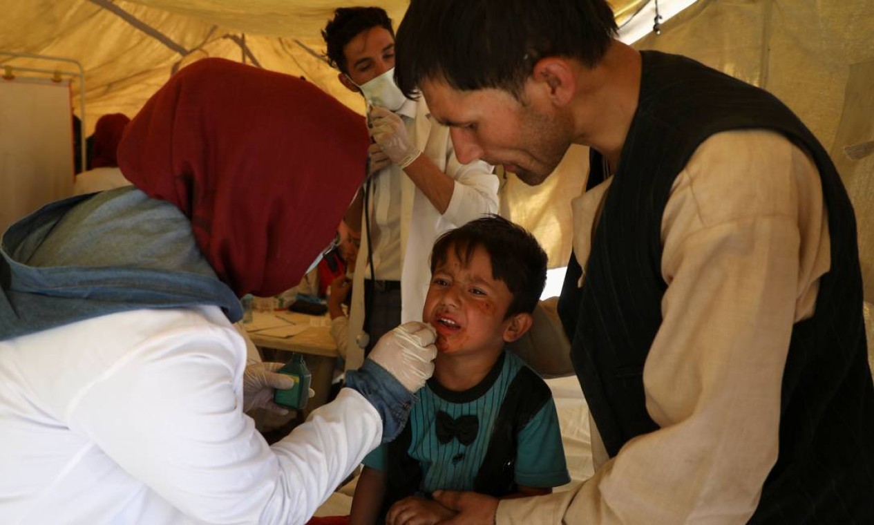 Uma criança recebe tratamento médico em um posto improvisado. De acordo com a Cruz Vermelha, centenas de milhares de civis afegãos estão em risco com a intensificação dos combates Foto: REUTERS