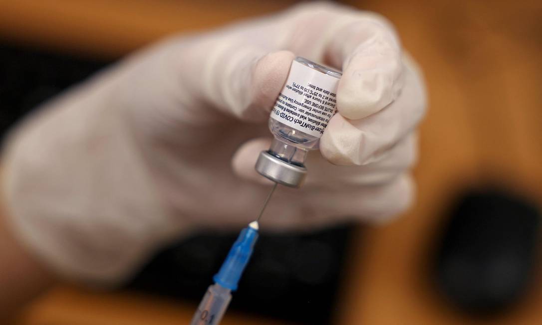 Profissional de saúde prepara dose da vacina da Pfizer contra Covid-19 Foto: MENAHEM KAHANA / AFP