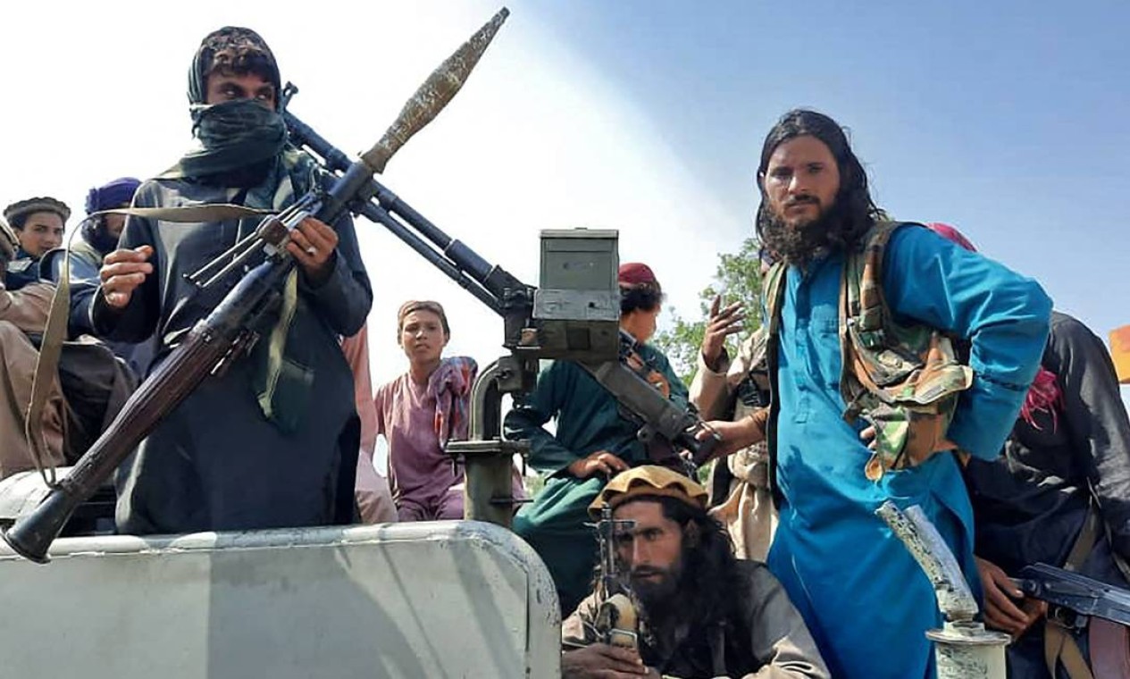 Combatentes talibãs ostentam armamento pesado sobre um veículo em uma rua na província de Laghman Foto: - / AFP
