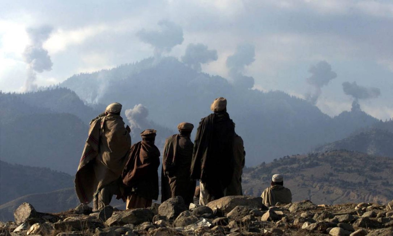 Soldados afegãos assistem a várias explosões de bombardeios dos EUA nas montanhas Tora Bora, no Afeganistão Foto: ERIK DE CASTRO / REUTERS - 16/12/2001