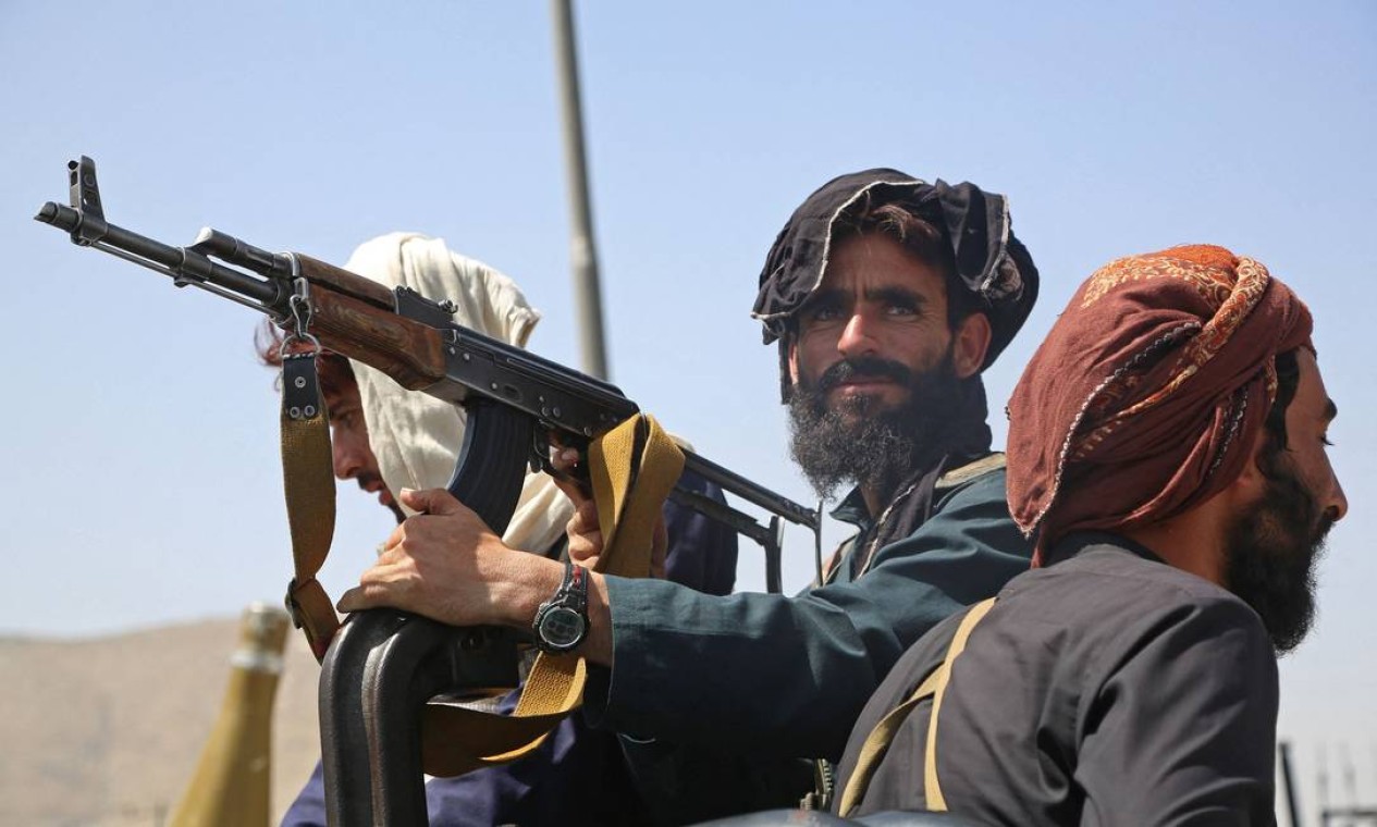 Combatentes do Talibã montam guarda em um veículo ao longo da estrada em Cabul Foto: - / AFP
