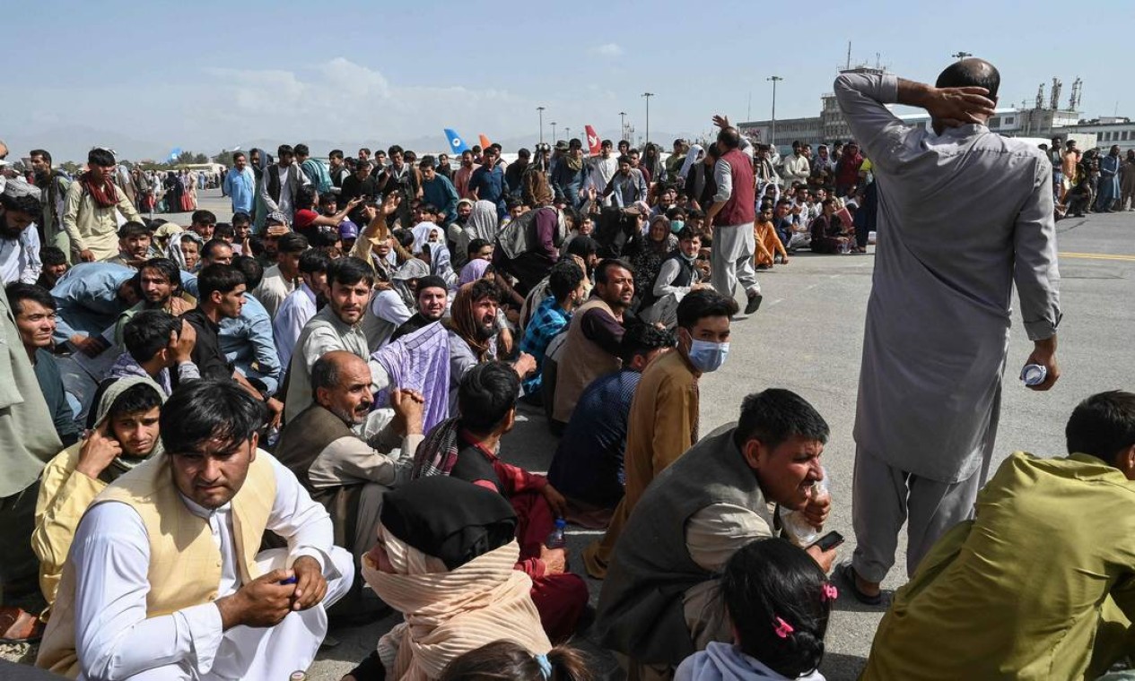 Passageiros afegãos ocupam a pista do aeroporto de Cabul em tentativa de fugir do país Foto: WAKIL KOHSAR / AFP