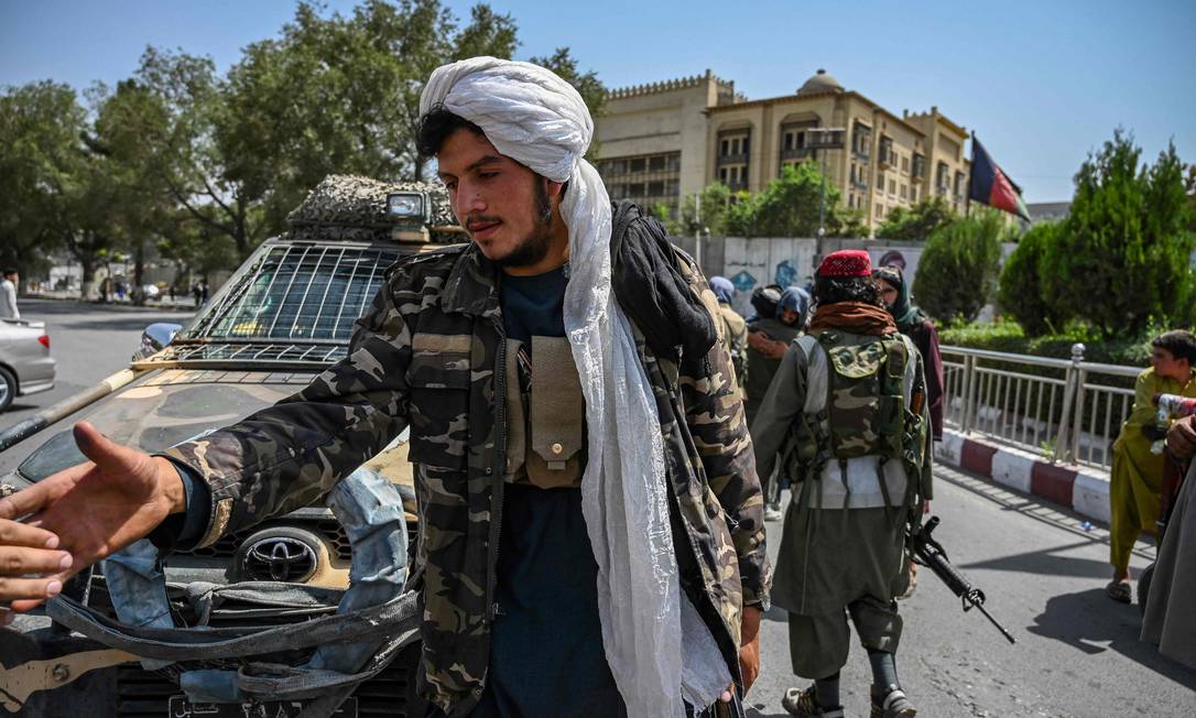 Membro dos talibãs impede passagem de pessoas em estrada que leva ao aeroporto de Cabul, no Afeganistão Foto: WAKIL KOHSAR / AFP